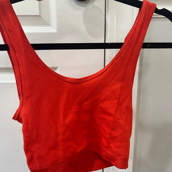 This is a red stretchy tank top with a cut in the stomach. - Picture 2 of 3